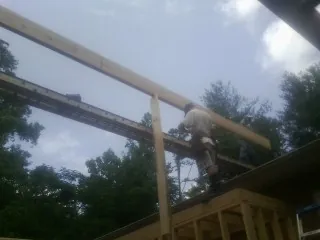 Carpenter setting a ridge beam over a new addition frame — Ice Dam Removal by Roofing Brothers in Harwood Heights