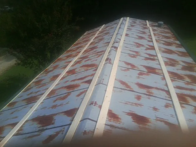 Rusted metal roof panels with new wood purlins before replacement — Storm Damage Roof Repair in Harwood Heights by Roofing Brothers