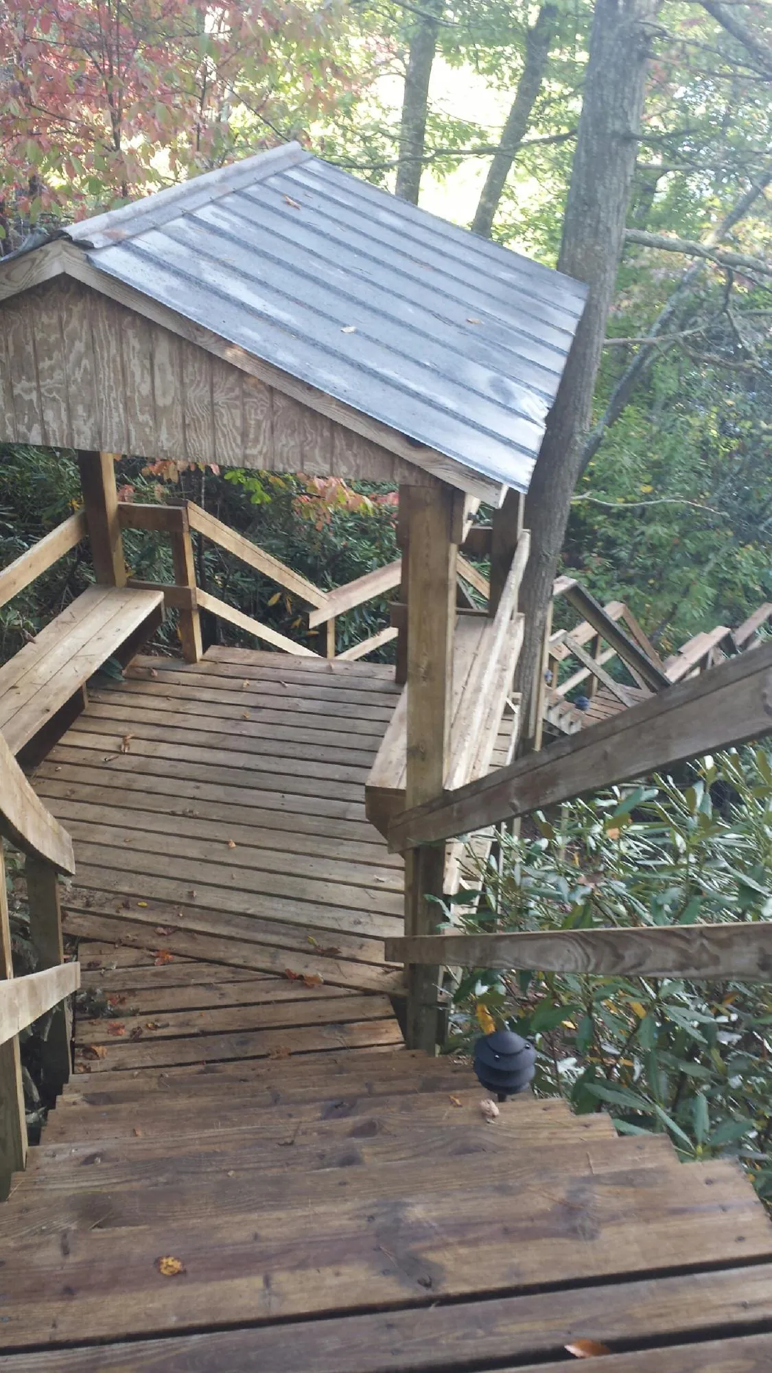Metal roofed shelter over wooden steps on a wooded walkway — Skylight Repair & Installation work by our crew in Harwood Heights